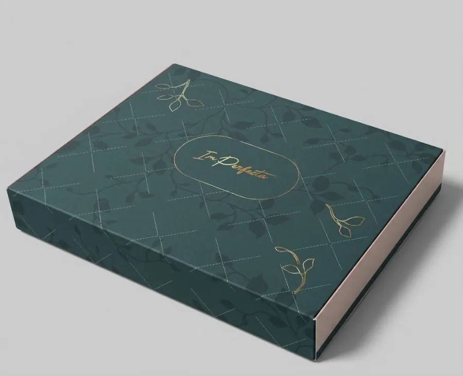 Caja de regalo de ImPerfecta cerrada: verde oscuro, con hojas dibujadas y el logo en dorado